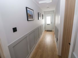 A hallway with pictures framed on the wall at Y Bwthyn in Burry Port