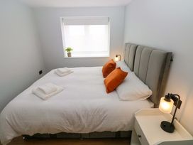 A bedroom with a bed and bedside table at Y Bwthyn in Burry Port