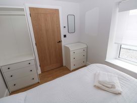 A bedroom with a bed and dresser at Y Bwthyn Burry Port