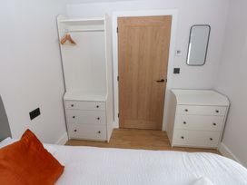 A bedroom with a wardrobe and drawer unit at Y Bwthyn in Burry Port