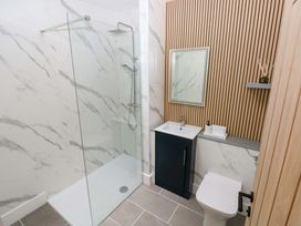 A bathroom with a shower, sink, and toilet at Y Bwthyn in Burry Port