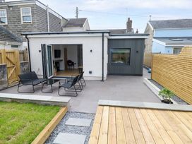 An outdoor patio with chairs and a table at Y Bwthyn Burry Port