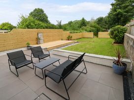 A garden with seating area and grass at Y Bwthyn in Burry Port