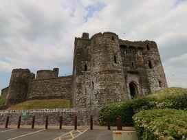 A castle with towers and walls in a parking area at Y Bwthyn in Burry Port
