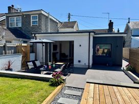 A house with a patio furniture and garden at Y Bwthyn Pembrey