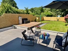 A garden with outdoor furniture and deck at Y Bwthyn in Pembrey