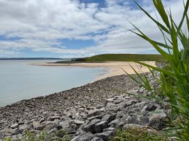A beach with sand and rocks at Y Bwthyn Pembrey