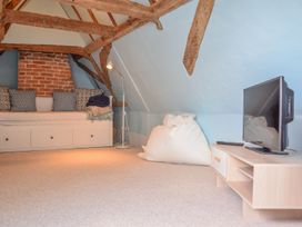 An attic with a sofa and television at Beresford House in Woodbridge