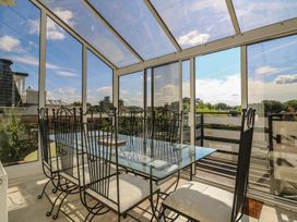 A conservatory with a glass table and chairs at Beresford House in Woodbridge