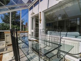 A conservatory with a glass table and chairs at Beresford House in Woodbridge