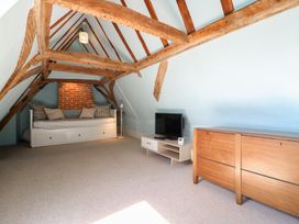 An attic with a sofa bed and a television at Beresford House in Woodbridge