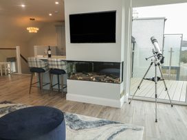 A living room with a fireplace and a telescope at 2 Ard an Chuain Dunfanaghy