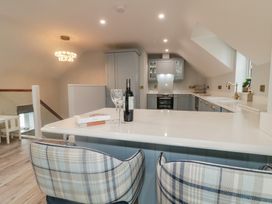 A kitchen with bar stools and a wine bottle at 2 Ard an Chuain Dunfanaghy