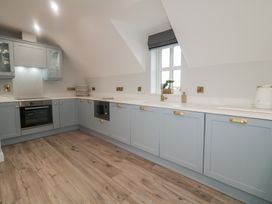 A kitchen with cabinets, oven, sink, and window at 2 Ard an Chuain Dunfanaghy