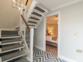 A hallway with a staircase and a doorway to a bedroom at 2 Ard an Chuain Dunfanaghy