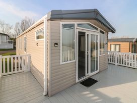 A mobile home with a deck and glass door at Plot 243 - Coldingham Bay Leisure Park, Eyemouth