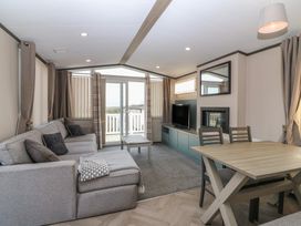 A living room with a sofa and dining table at Plot 243 - Coldingham Bay Leisure Park Eyemouth