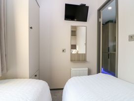 A bedroom with two beds, a television, and a wardrobe at Plot 243 - Coldingham Bay Leisure Park Eyemouth