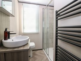 A bathroom with a sink, toilet, shower, and towel radiator at Plot 243 - Coldingham Bay Leisure Park Eyemouth