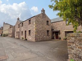 A stone building with windows and a door at 4 Mellbecks Mews in Kirkby Stephen