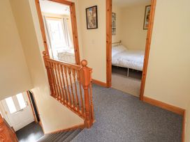 A hallway with a staircase and doors to a bedroom at 4 Mellbecks Mews Kirkby Stephen