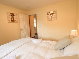 A bedroom with a bed and door at 4 Mellbecks Mews Kirkby Stephen