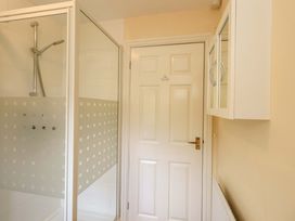 A bathroom with a shower and a door at 4 Mellbecks Mews in Kirkby Stephen