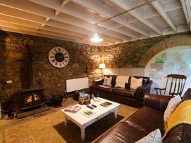 A living room with a sofa and stove at Childwall Cottage in TULLOGHER