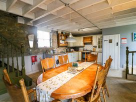 A dining room with a wooden table and chairs at Childwall Cottage TULLOGHER