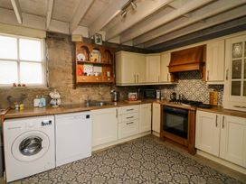 A kitchen with appliances and shelving at Childwall Cottage TULLOGHER