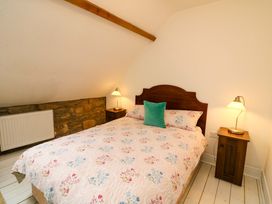 A bedroom with a bed and nightstand at Childwall Cottage TULLOGHER