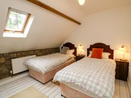A bedroom with twin beds and bedside tables at Childwall Cottage TULLOGHER