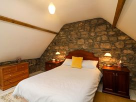 A bedroom with a bed and nightstands at Childwall Cottage TULLOGHER