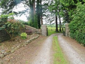 An outdoor area with a gravel driveway and gate at Childwall Cottage TULLOGHER