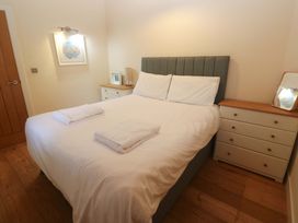 A bedroom with a bed, nightstand, and drawers at The Lodge at Lamburn