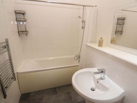 A bathroom with a bath shower and sink at The Lodge at Lamburn