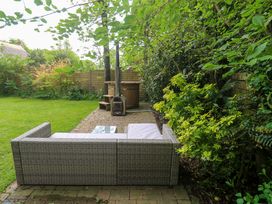 A garden with an outdoor sofa and hot tub at The Lodge at Lamburn
