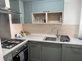 A kitchen with a sink, gas stove, and cabinets at 3 Newboro Terrace Conwy