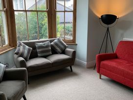 A snug with a sofa, armchair and lamp at 3 Newboro Terrace in Conwy