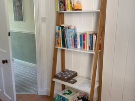 A bookshelf with books and games in a hallway at 3 Newboro Terrace, Conwy