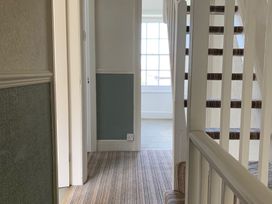 A hallway with a staircase and a window at 3 Newboro Terrace in Conwy