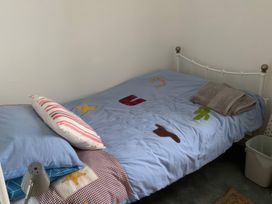 A bedroom with a bed, pillow, towel, and lamp at 3 Newboro Terrace in Conwy