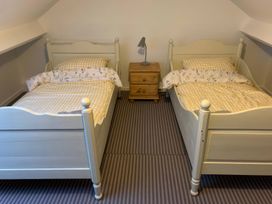 A bedroom with two single beds and a nightstand at 3 Newboro Terrace in Conwy