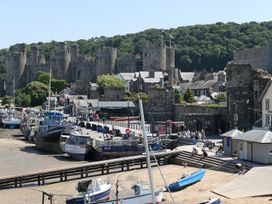 A dock with boats and a castle in the background at 3 Newboro Terrace in Conwy