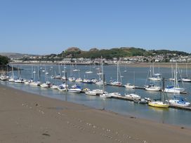 A view of boats docked by the water with hills and houses in the background at 3 Newboro Terrace in Conwy