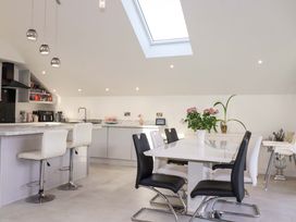 A kitchen with bar stools and a dining table at Meadow Retreat in Bodmin