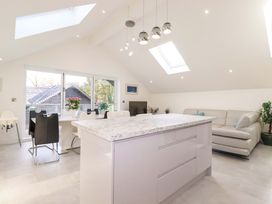 A kitchen with an island and dining area at Meadow Retreat in Bodmin