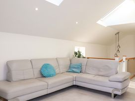A living room with a sofa and cushion at Meadow Retreat in Bodmin