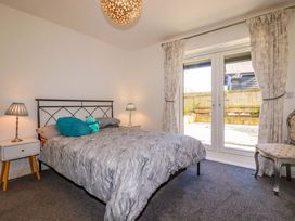 A bedroom with a bed and sliding door at Meadow Retreat in Bodmin