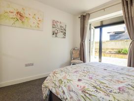 A bedroom with a bed and a chair at Meadow Retreat in Bodmin